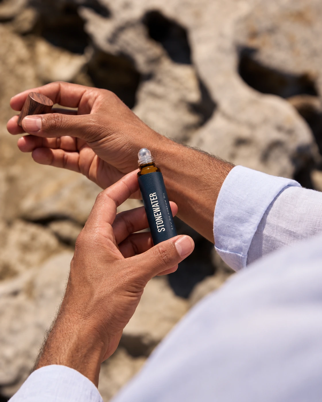 A gentleman applying Stonewater roll-on oil to his wrist